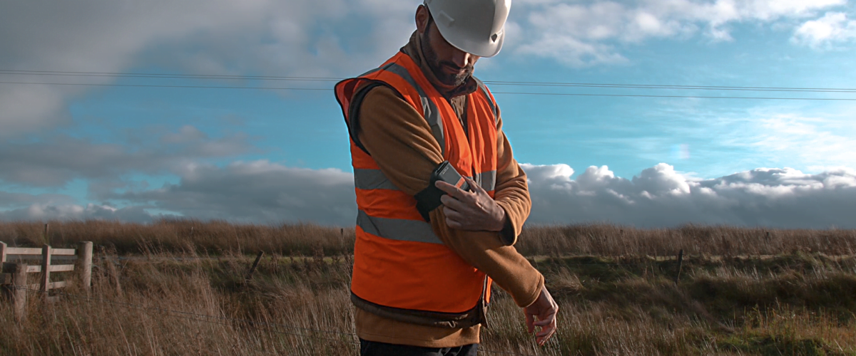 Photograph of an outdoor lone worker using a GPS Device to Check-in to confirm he is safe.