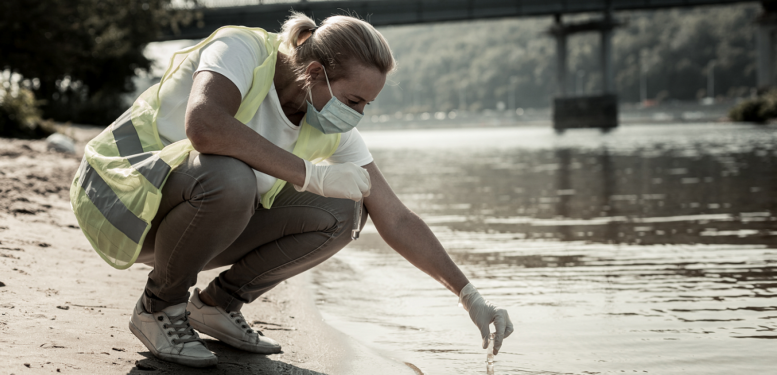 Image of a vulnerable worker - a female lone worker undertaking a water inspection at a riverside.