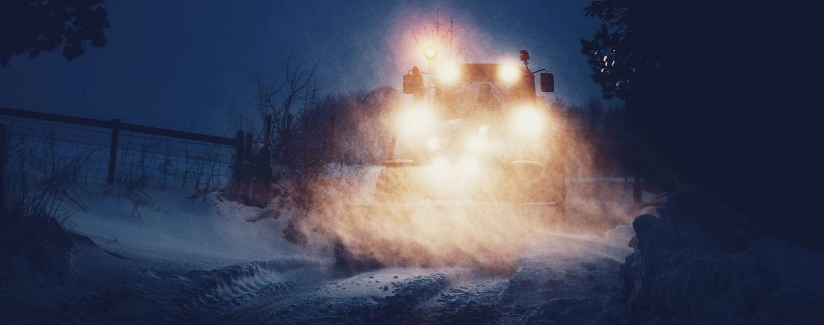 Working in the dark - truck with headlights on being driven at night in the snow. Image courtesy of Dan Cook on unsplash.