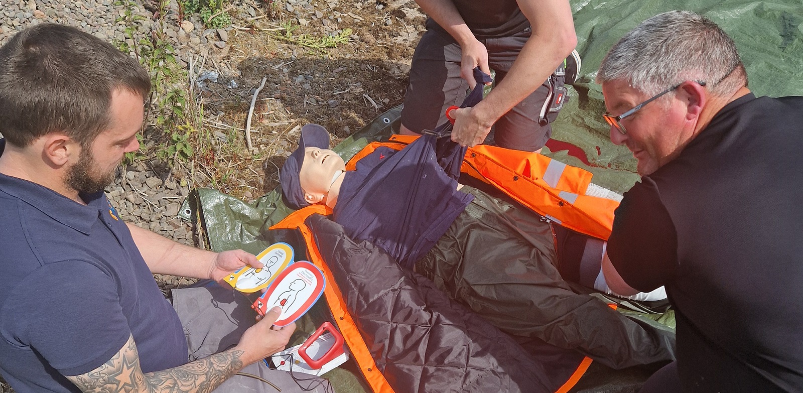 Photograph of SLP First Aid training session with 3 participants practising on a QCPR manikin.