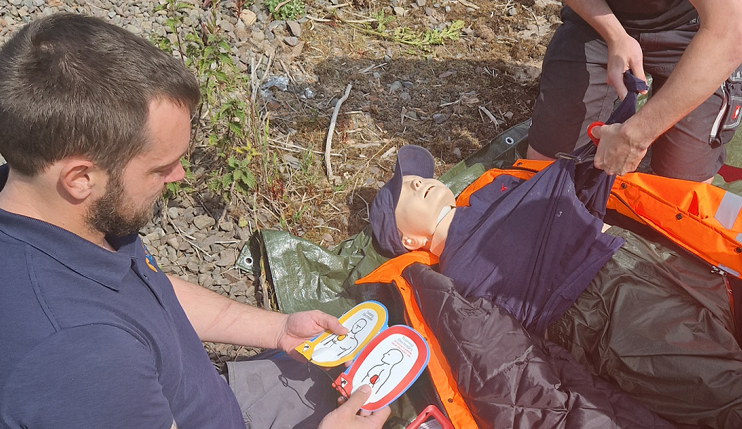 Photograph close up of SLP First Aid training with participants using a QCPR manikin.