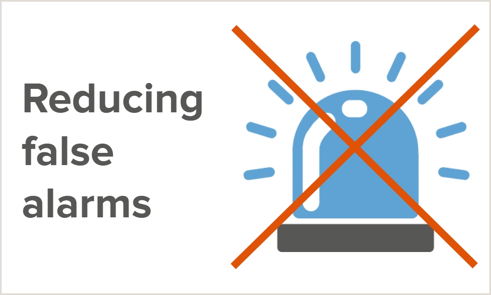 Illustration of an activated emergency blue light with two orange lines forming a cross over the top, crossing the light out with the words "Reducing false alarms".